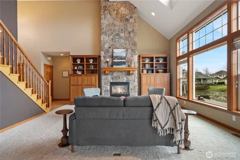 a living room with fireplace furniture and a large window