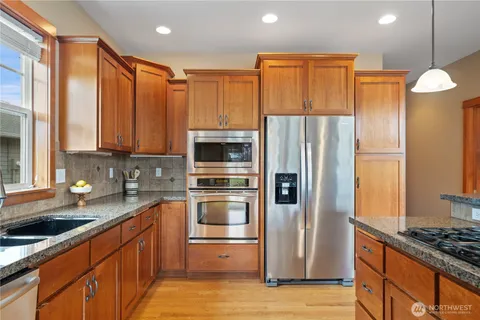 a kitchen with stainless steel appliances granite countertop a refrigerator and a stove top oven