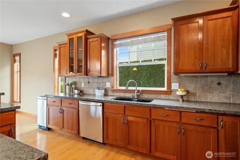 a kitchen with stainless steel appliances granite countertop a sink stove and cabinets