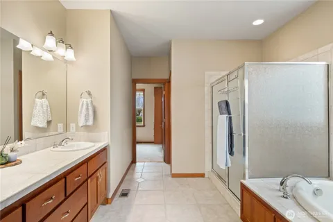 a spacious bathroom with a double vanity sink a mirror and a bathtub