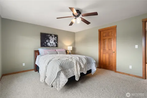 a spacious bedroom with a bed and a ceiling fan