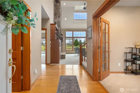 a view of a hallway with wooden floor and a potted plant