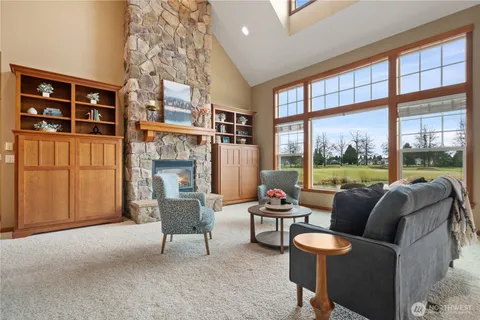 a living room with furniture a fireplace and a large window