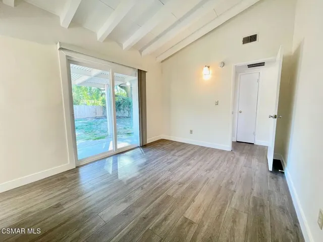 a view of a big room with wooden floor and windows