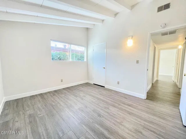 a view of a room with wooden floor and window