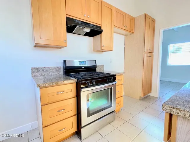 a kitchen with stainless steel appliances granite countertop a stove and a microwave