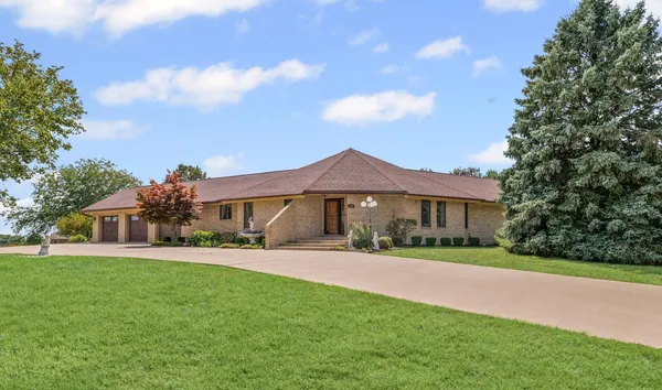 a front view of a house with a yard and trees
