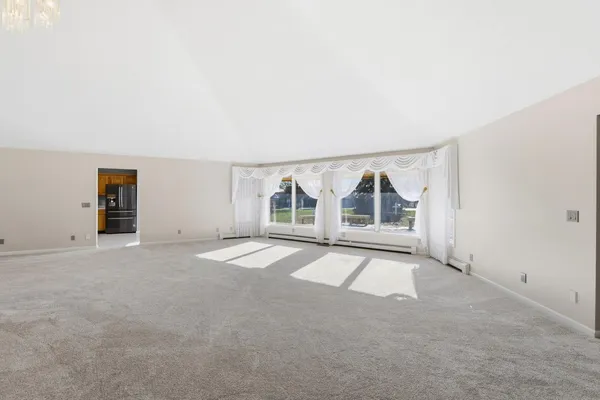 an empty room with ceiling fan and window