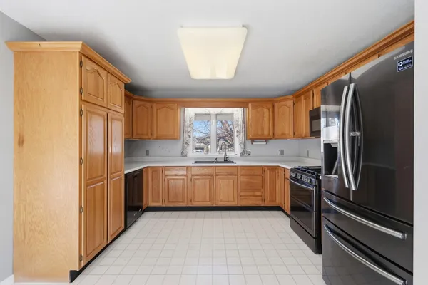 a kitchen with granite countertop stainless steel appliances a refrigerator stove top oven and sink