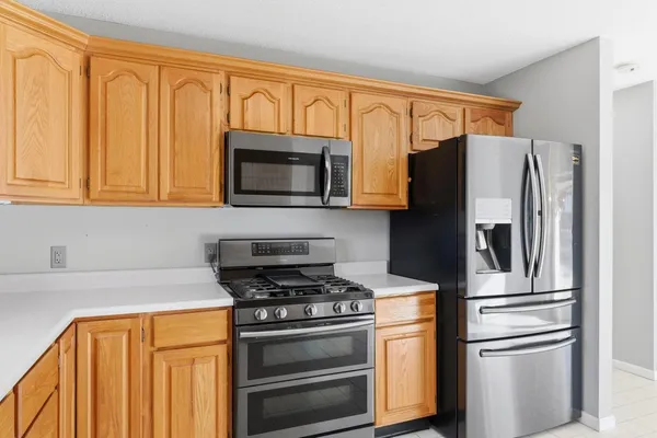 a kitchen with stainless steel appliances granite countertop a refrigerator stove and microwave