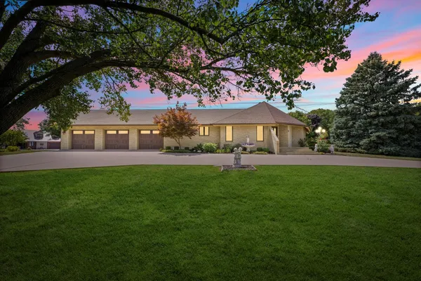 a front view of a house with yard and green space