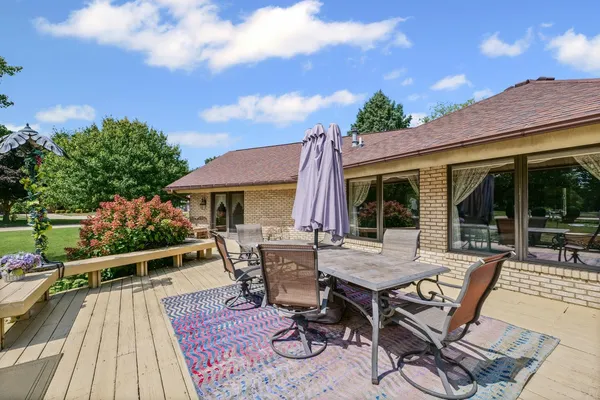 a roof deck with table and chairs a barbeque with wooden floor and fence
