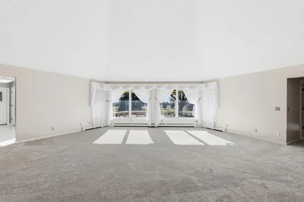 an empty room with window and painting on the wall