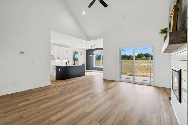 a view of a livingroom with wooden floor and a fireplace