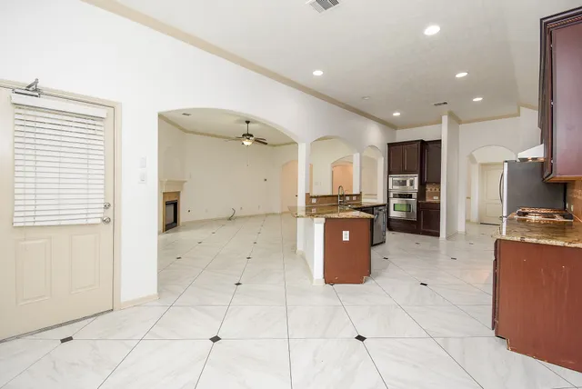 a kitchen with stainless steel appliances kitchen island granite countertop a refrigerator and a stove top oven