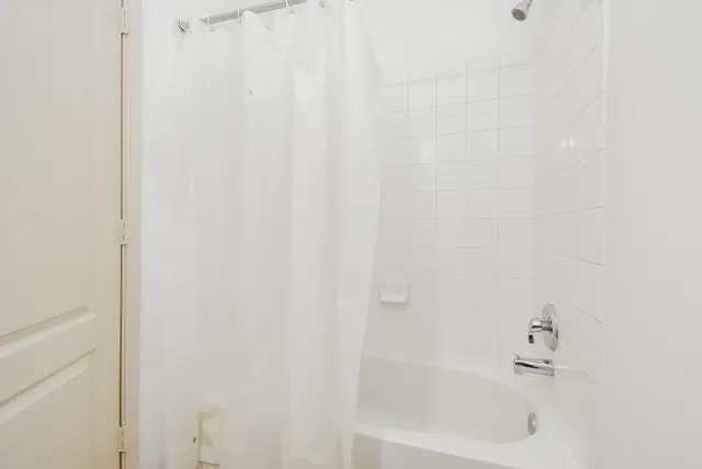 a white bath tub with a shower