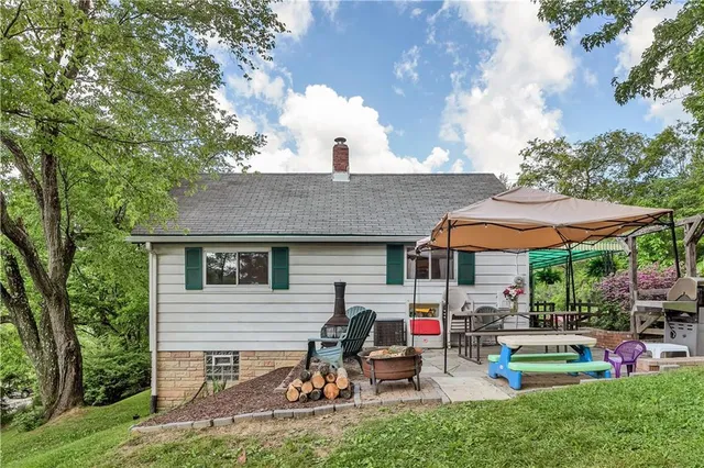 a view of a house with backyard sitting area and garden