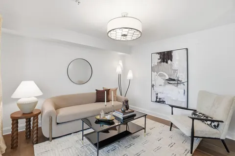 a living room with furniture a rug and a mirror