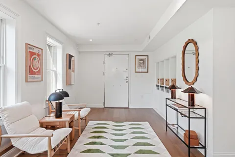 a bedroom with a bed a mirror on dresser and a window