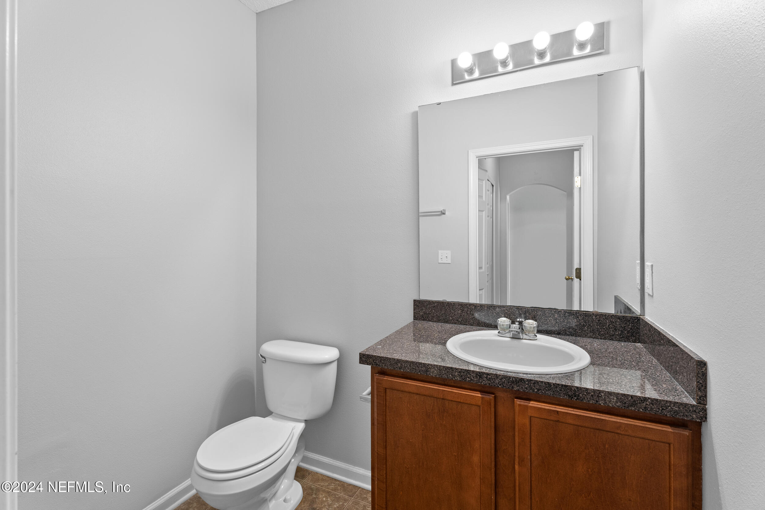 5260 Collins Road, Unit 1101 Jacksonville, FL 32244 - Photo 15 of 25 a bathroom with a toilet sink and mirror