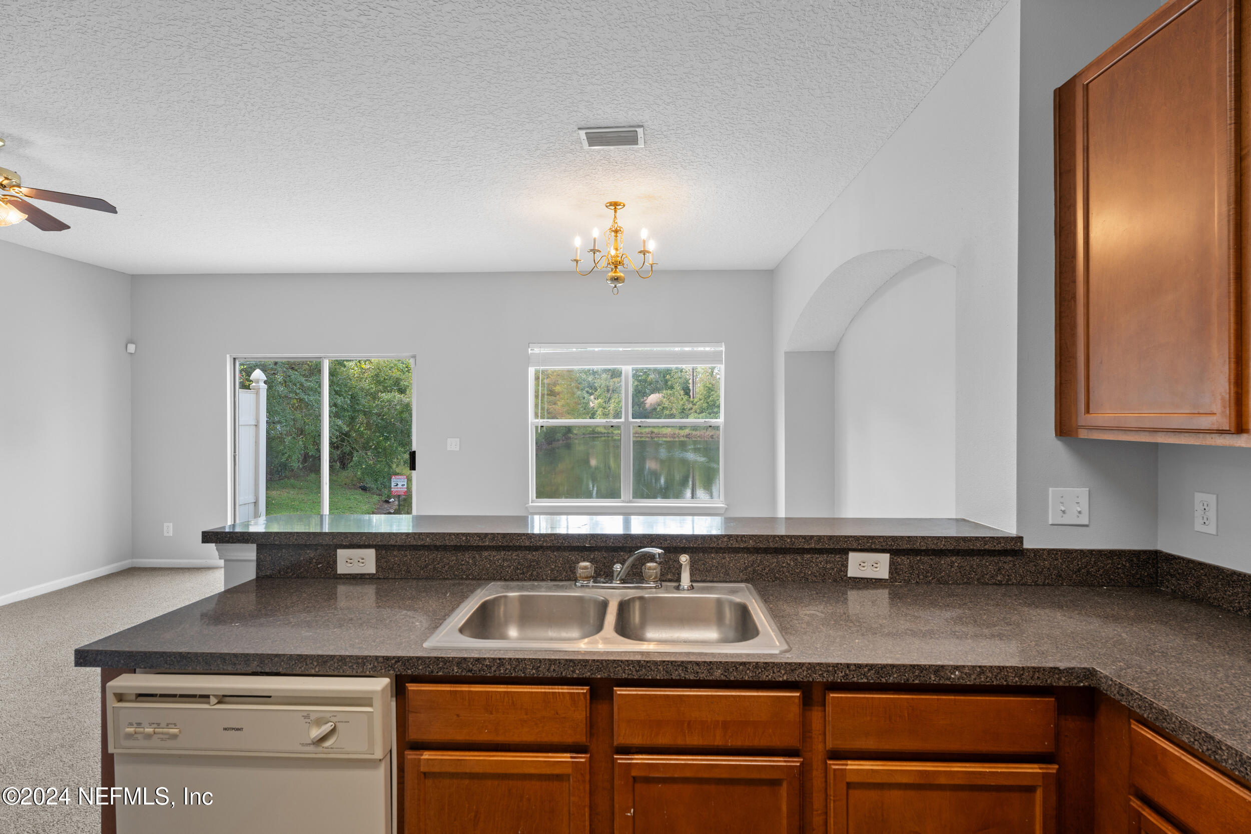 5260 Collins Road, Unit 1101 Jacksonville, FL 32244 - Photo 21 of 25 a kitchen with granite countertop stainless steel appliances sink a window and cabinets