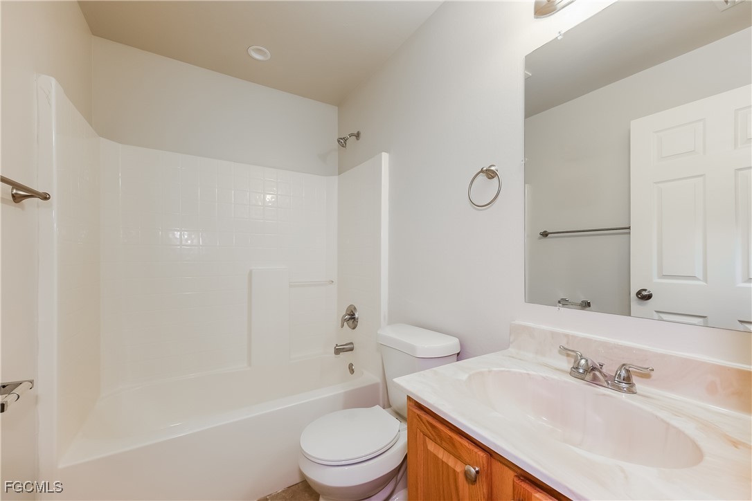 3004 15th Street West Lehigh Acres, FL 33971 - Photo 3 of 16 a bathroom with a sink a toilet and shower