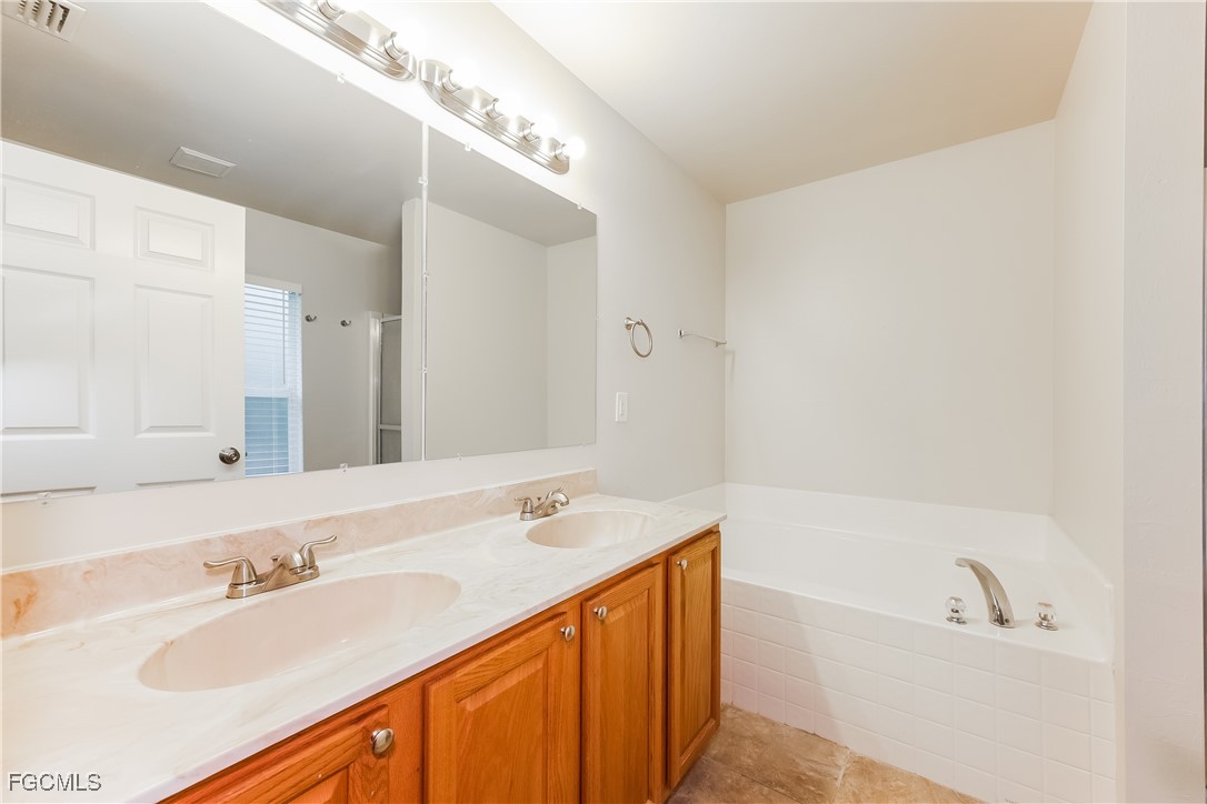 3004 15th Street West Lehigh Acres, FL 33971 - Photo 7 of 16 a bathroom with a tub sink and mirror