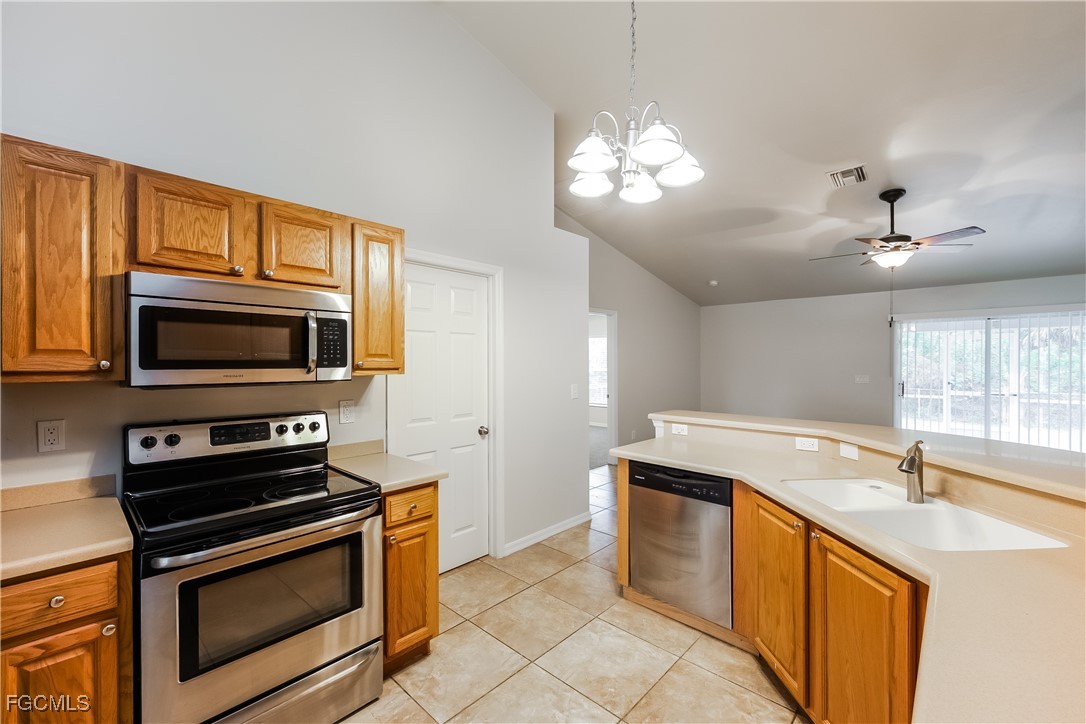 3004 15th Street West Lehigh Acres, FL 33971 - Photo 10 of 16 a kitchen with stainless steel appliances granite countertop a sink stove and microwave