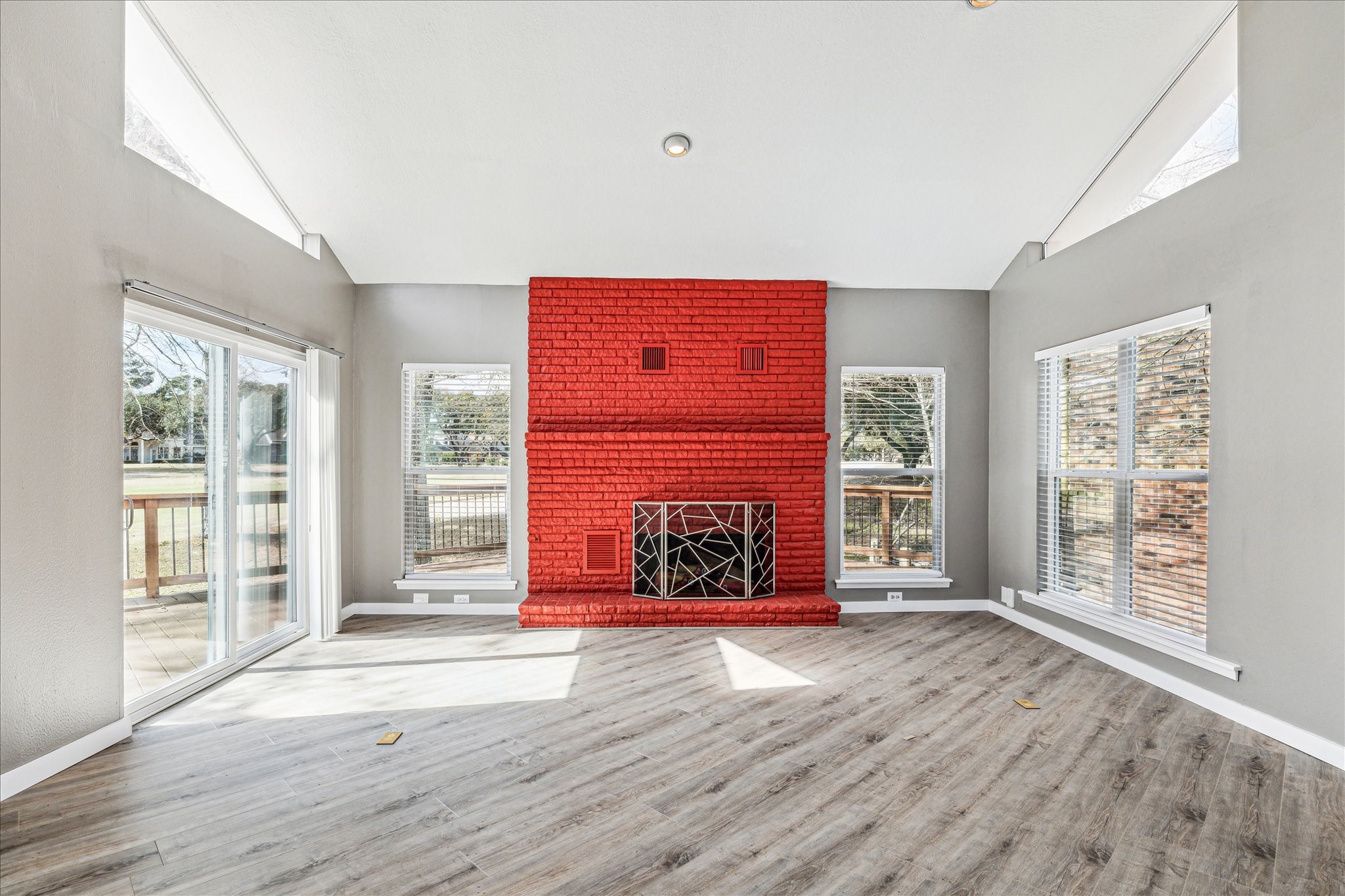 146 Dawns Edge Conroe, TX 77356 - Photo 13 of 39 wooden floor and fireplace with windows in an empty room