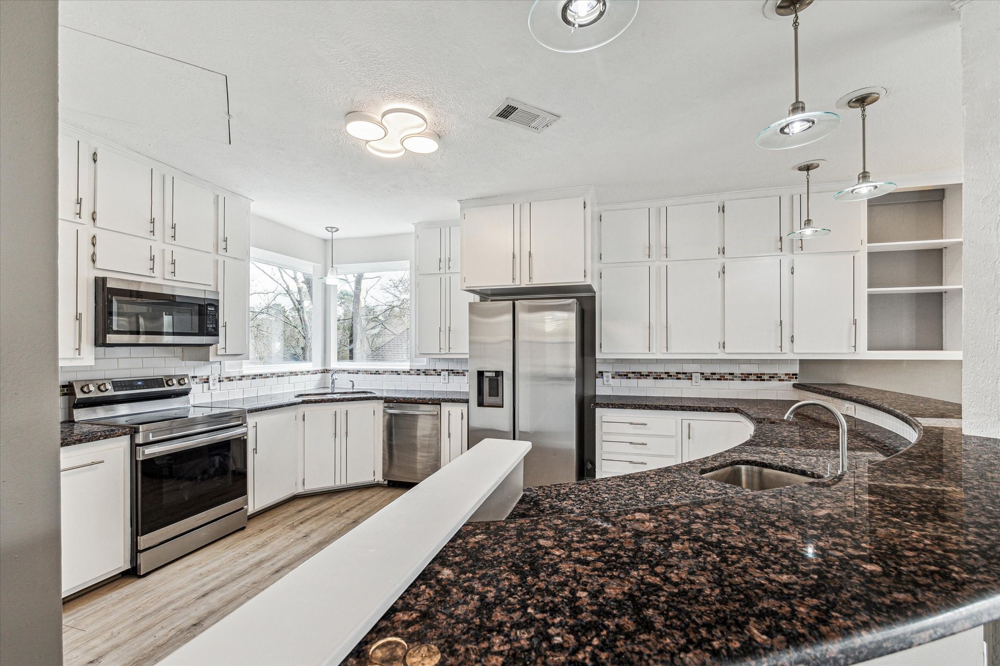 146 Dawns Edge Conroe, TX 77356 - Photo 17 of 39 a kitchen with a stove a sink and a refrigerator