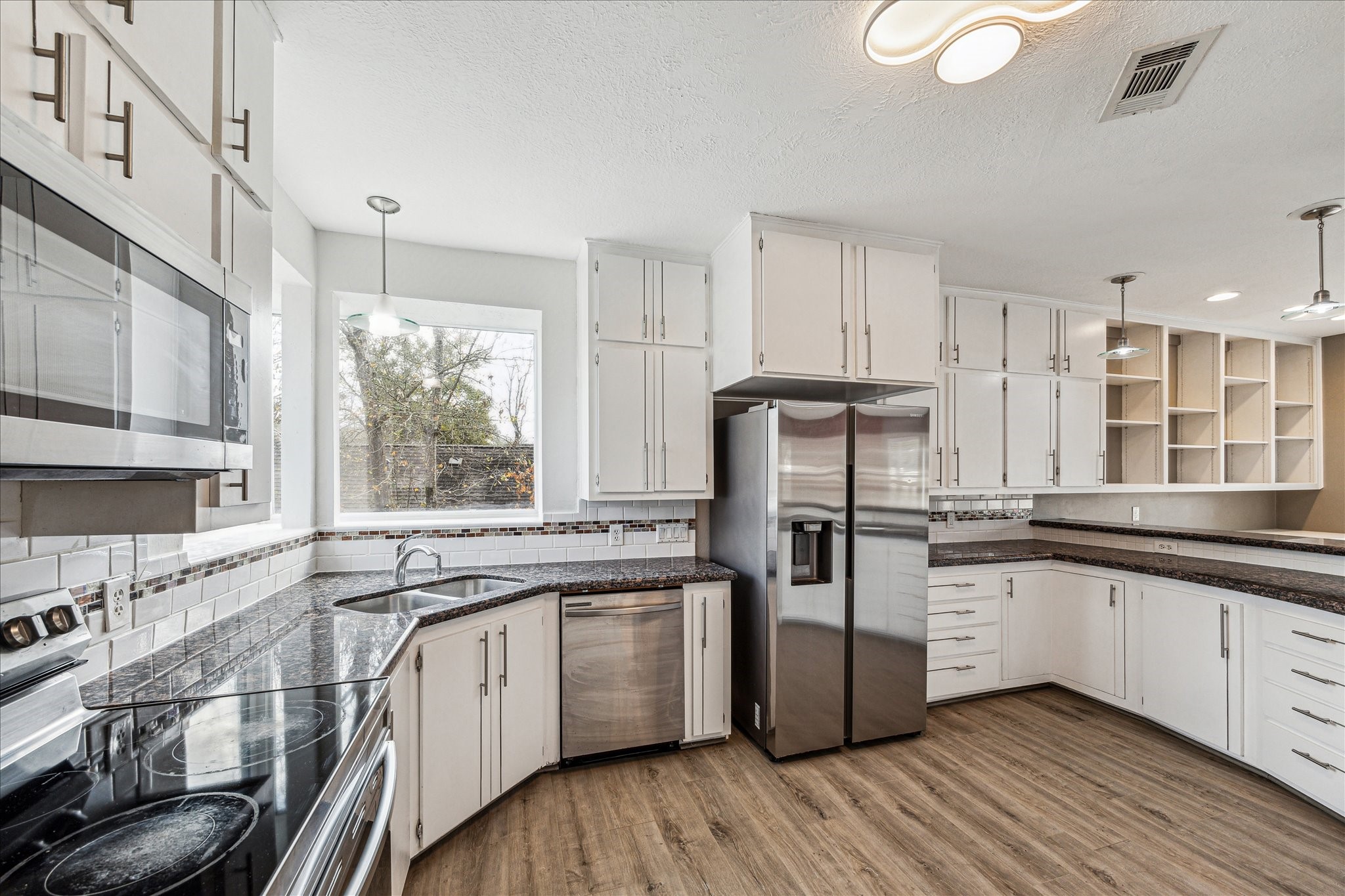 146 Dawns Edge Conroe, TX 77356 - Photo 18 of 39 a kitchen with stainless steel appliances granite countertop a stove and white cabinets