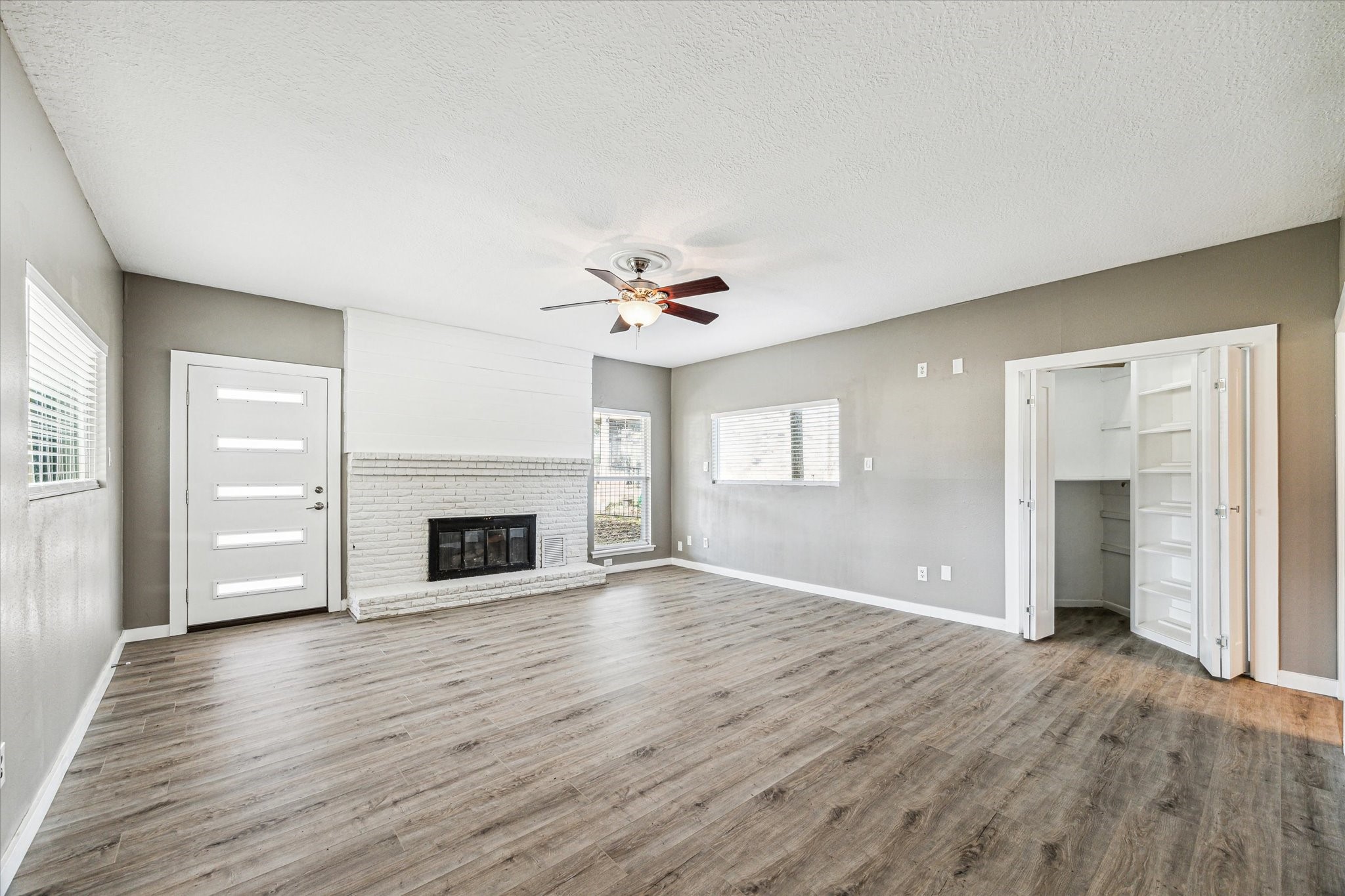 146 Dawns Edge Conroe, TX 77356 - Photo 20 of 39 an empty room with wooden floor fireplace and windows