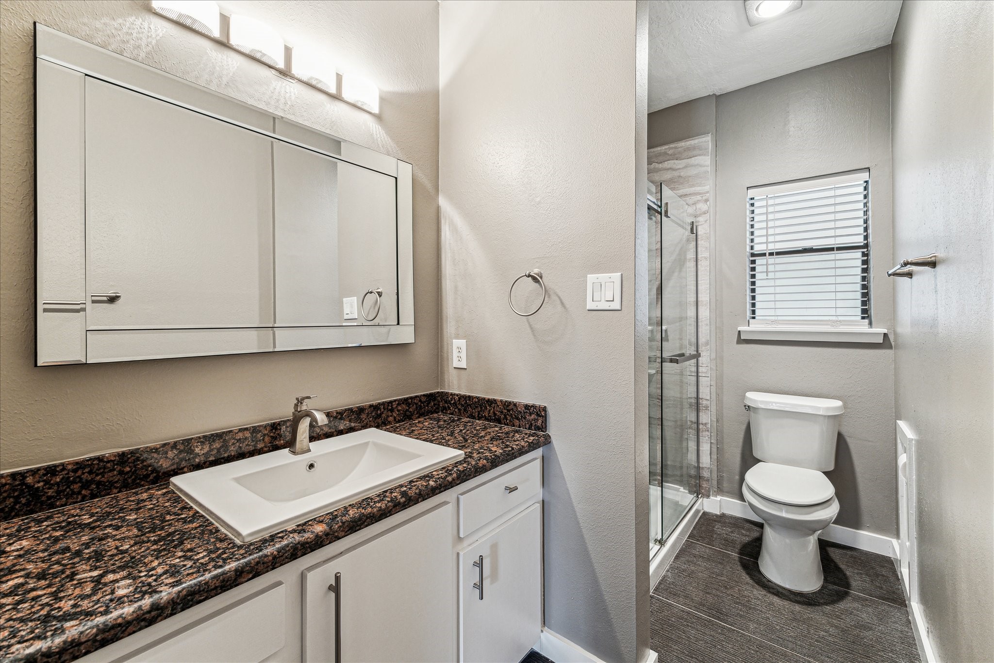 146 Dawns Edge Conroe, TX 77356 - Photo 26 of 39 a bathroom with a granite countertop sink a toilet and a mirror