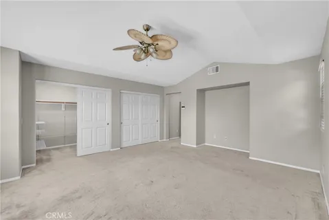 a view of an empty room and a chandelier fan