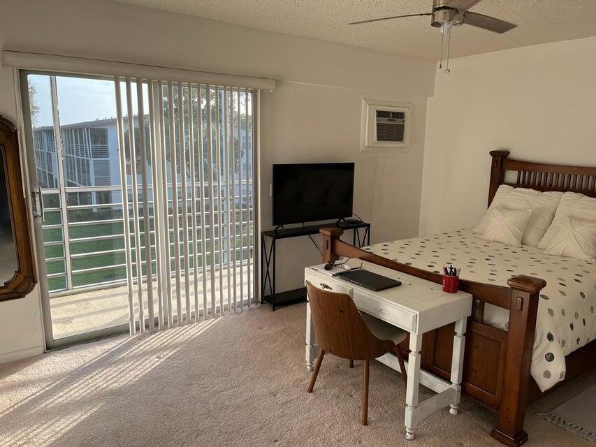 622 Fanshaw O, Unit 622 Boca Raton, FL 33434 - Photo 3 of 5 a bedroom with a bed and a flat tv screen