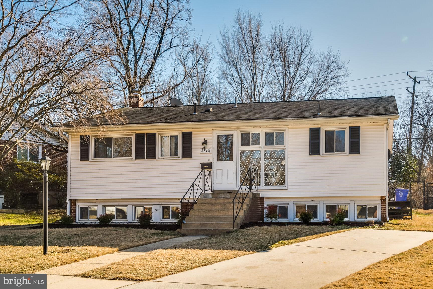 a front view of a house with a tree