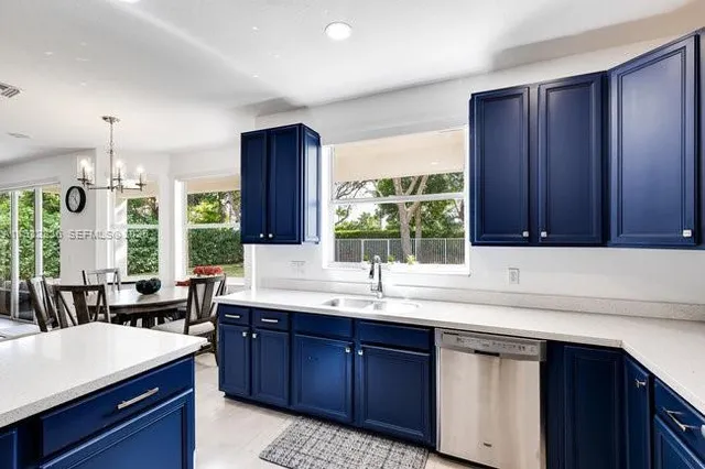 a kitchen with stainless steel appliances granite countertop wooden cabinets a sink and a large window