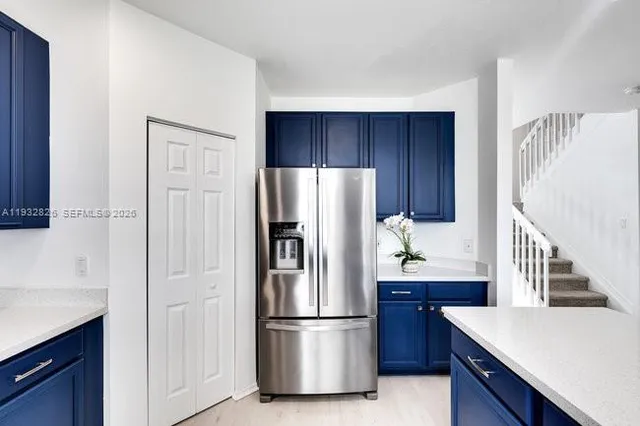 a kitchen with stainless steel appliances granite countertop a refrigerator a stove and a sink with wooden cabinets