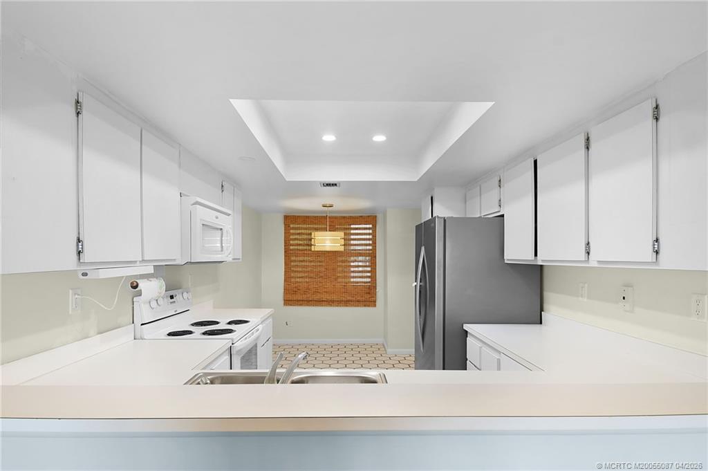 529 Northeast Plantation Road, Unit 105 Jensen Beach, FL 34957 - Photo 11 of 36 a kitchen with stainless steel appliances granite countertop a sink stove and refrigerator