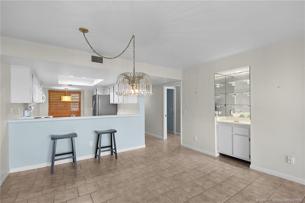 529 Northeast Plantation Road, Unit 105 Jensen Beach, FL 34957 - Photo 12 of 36 a view of a livingroom with furniture wooden floor chandelier and windows