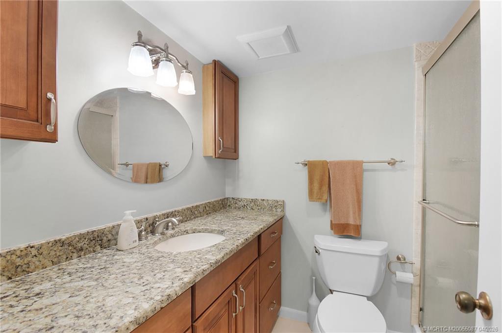 529 Northeast Plantation Road, Unit 105 Jensen Beach, FL 34957 - Photo 17 of 36 a bathroom with a granite countertop sink and a mirror
