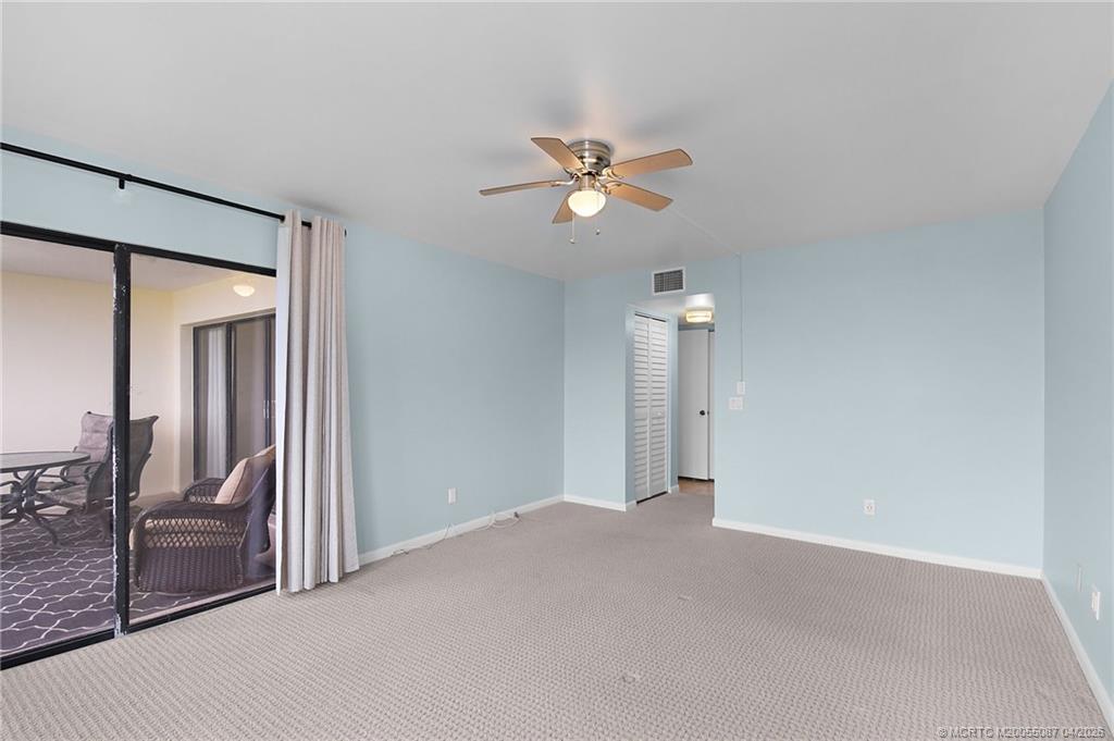 529 Northeast Plantation Road, Unit 105 Jensen Beach, FL 34957 - Photo 20 of 36 a view of a room with a ceiling fan and hardwood floor