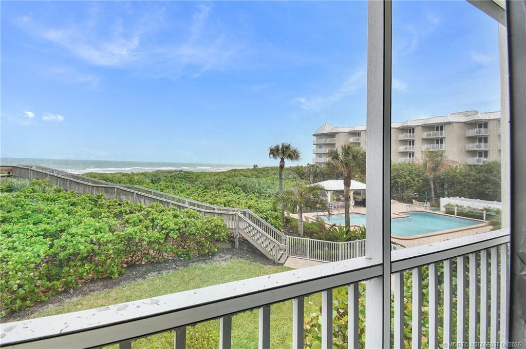 529 Northeast Plantation Road, Unit 105 Jensen Beach, FL 34957 - Photo 2 of 36 a view of a balcony with floor to ceiling windows with wooden fence