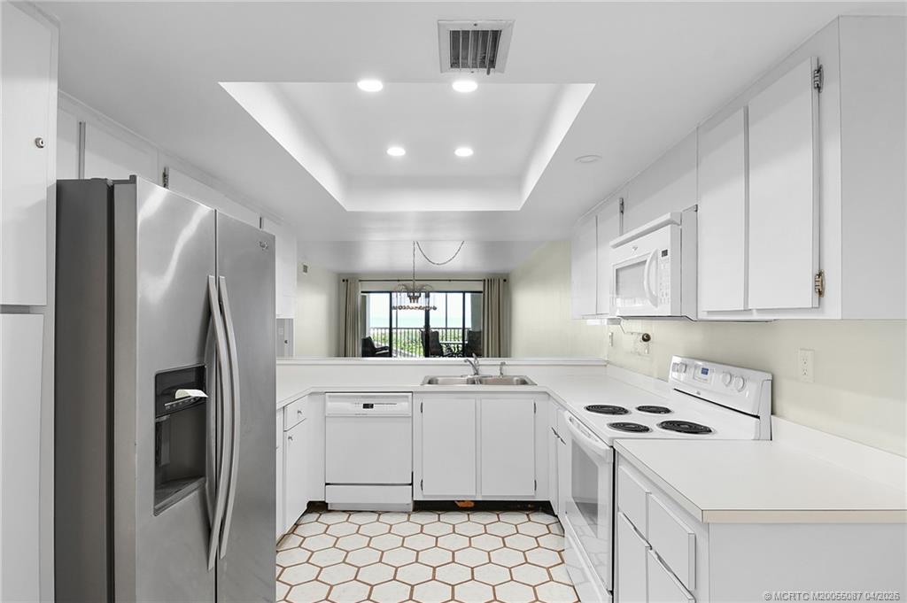 529 Northeast Plantation Road, Unit 105 Jensen Beach, FL 34957 - Photo 10 of 36 a kitchen that has a sink a refrigerator and a stove