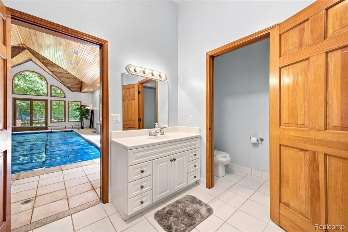 8610 Ferry Road Grosse Ile, MI 48138 - Photo 39 of 55 Indoor pool with vaulted wood-paneled ceiling and large arched windows