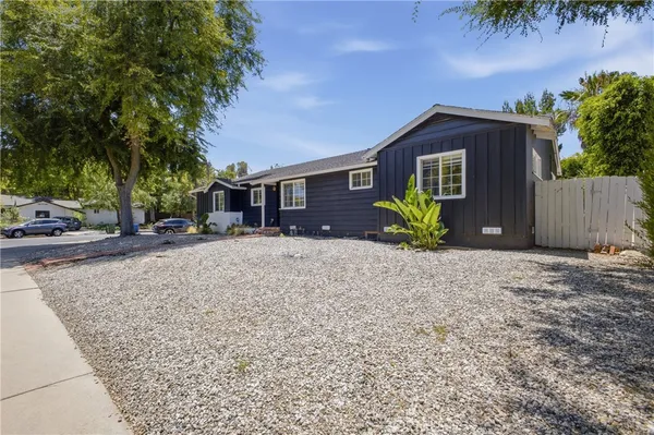 a front view of a house with a yard and tree