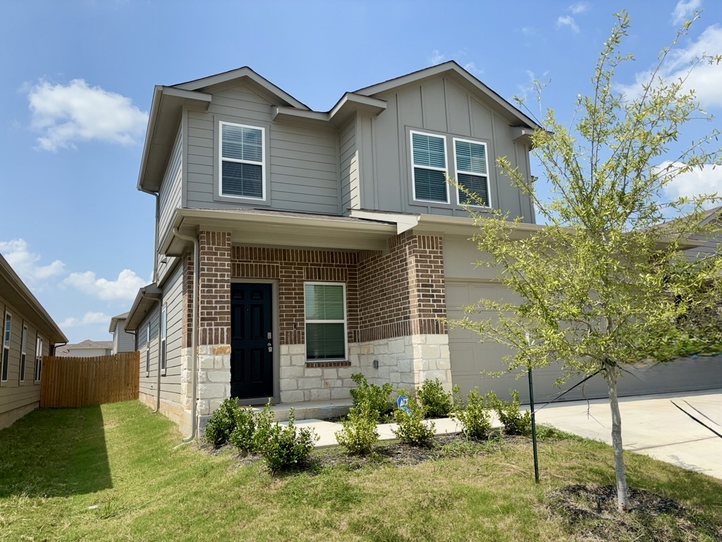 13525 Open Wagon Trail Elgin, TX 78621 - Photo 1 of 26 View of front of home with a porch, a garage, driveway, and brick siding