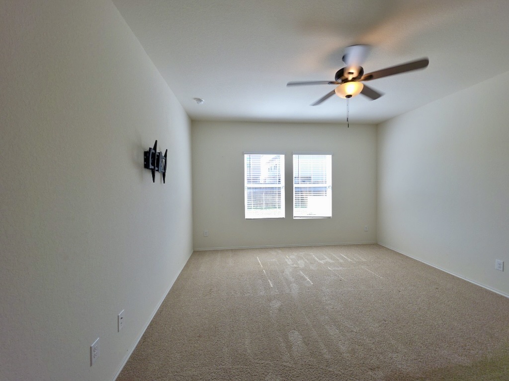 13525 Open Wagon Trail Elgin, TX 78621 - Photo 11 of 26 Primary bedroom featuring a ceiling fan and light carpet