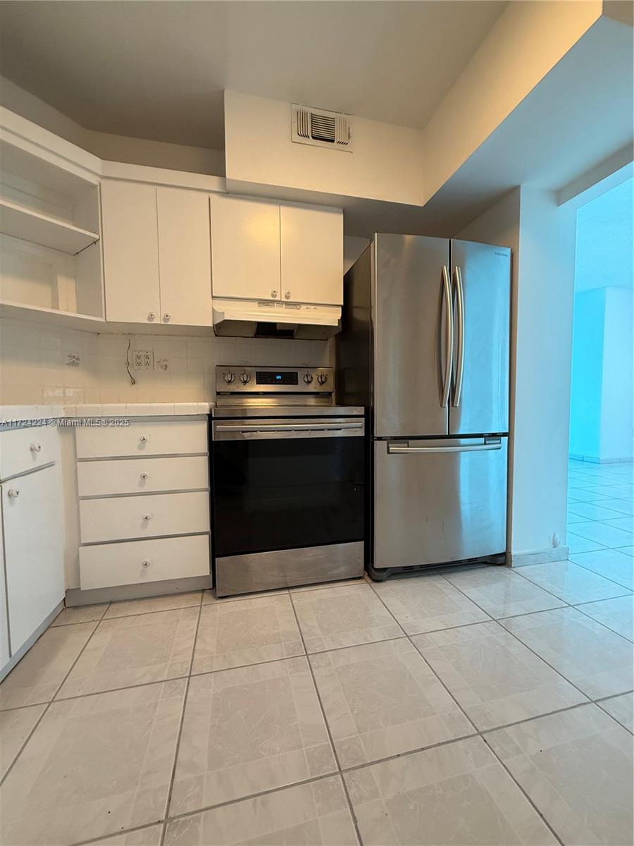 500 Bayview Drive, Unit 1031 Sunny Isles Beach, FL 33160 - Photo 11 of 40 a kitchen with cabinets and steel stainless steel appliances