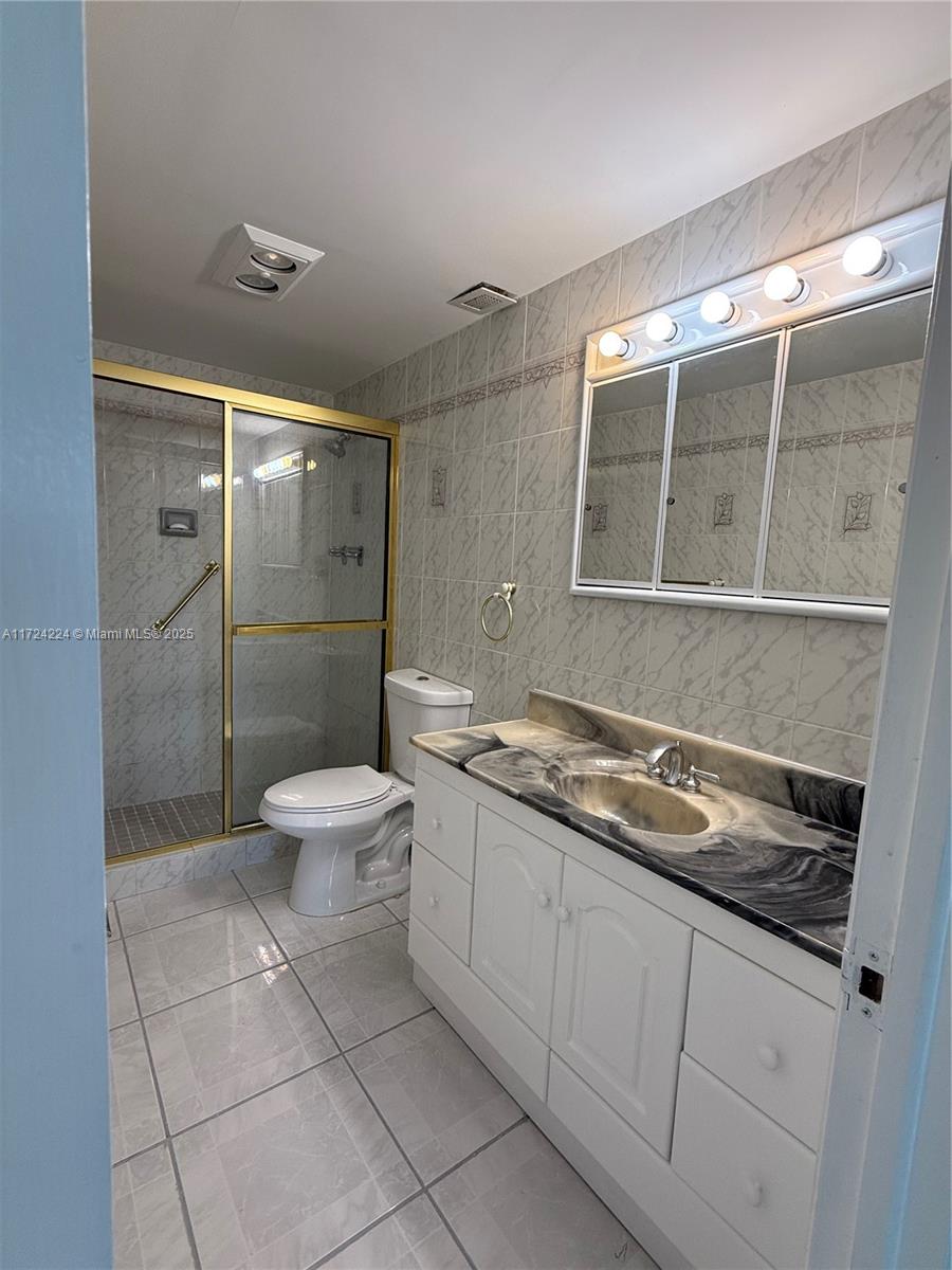 500 Bayview Drive, Unit 1031 Sunny Isles Beach, FL 33160 - Photo 30 of 40 a bathroom with a granite countertop sink a toilet and shower
